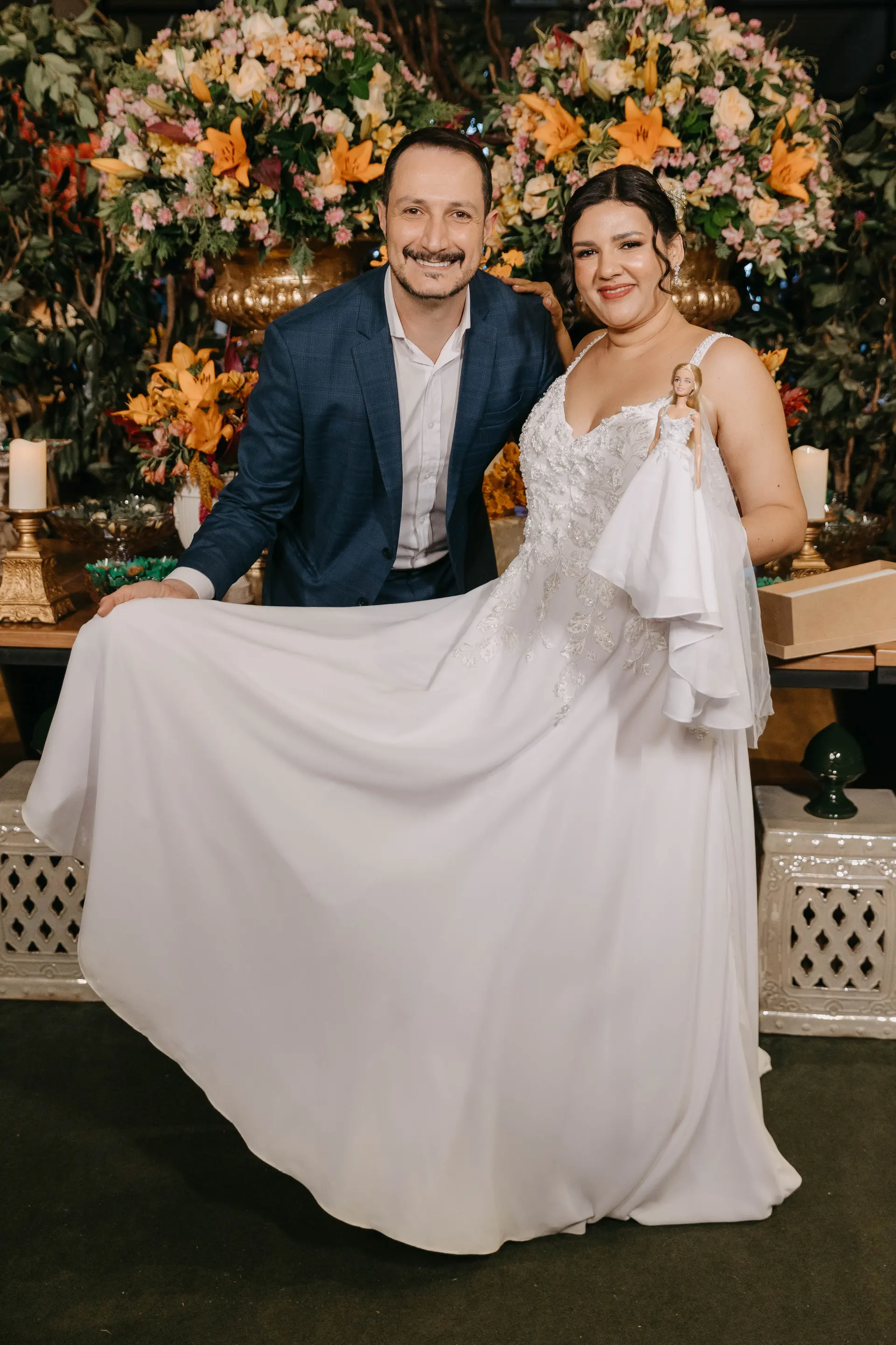 Noiva ao lado da miniatura do vestido, criada pelo estilista Luis Paulo